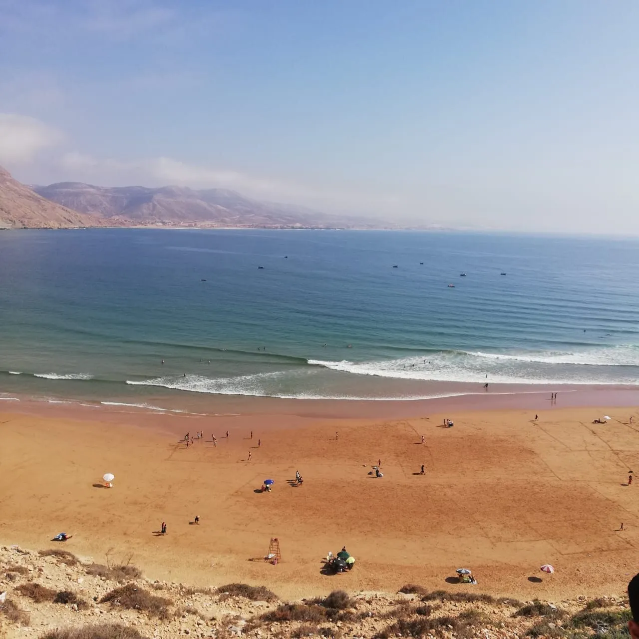 Vue aérienne de la baie d'Imsouane — la plage et le port avec les montagnes de l'Anti-Atlas en arrière-plan