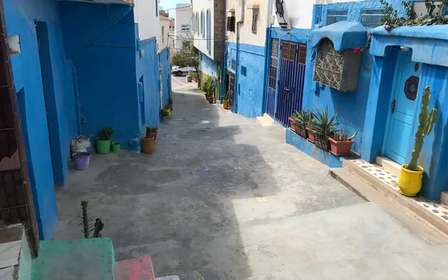 Ruelle traditionnelle de Taghazout aux maisons bleues et blanches — référence locale dont s'inspire l'architecture contemporaine du Fairmont Taghazout Bay