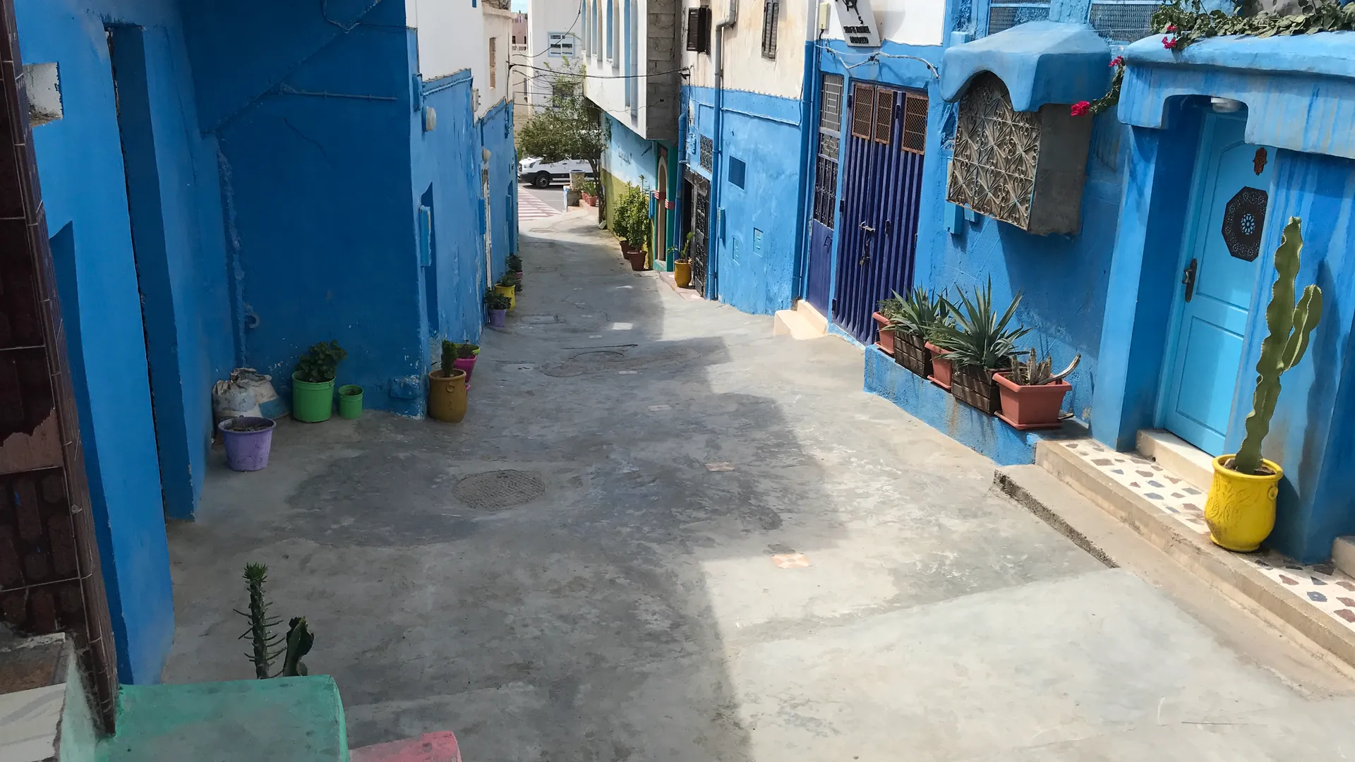 Ruelle traditionnelle de Taghazout aux maisons bleues et blanches — référence locale dont s'inspire l'architecture contemporaine du Fairmont Taghazout Bay